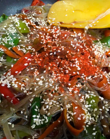 Стеклянная рисовая лапша фунчоза с овощами и грибами в сковороде вок