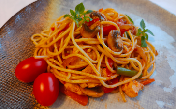 Спагетти с овощами, курицей и соевым соусом в сковороде